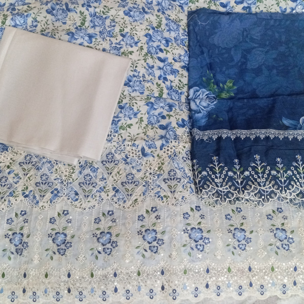 AllurifyYou unstitched lawn suit set with blue and white floral print, intricate embroidery, and scalloped borders.